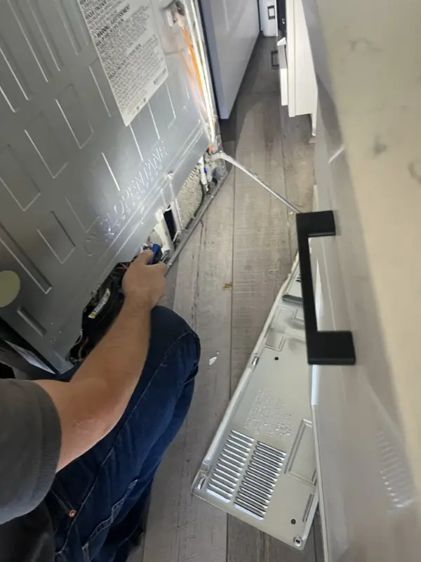 Refrigerator repair with the lower rear panel removed