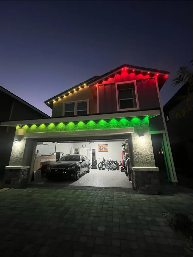 Permanent eave lights set to red and green for the holidays over a garage, Las Vegas